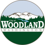 City of Woodland Logo - Featuring Mountains, River, and Evergreen Trees